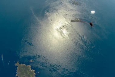 Reflet du soleil et parachutiste tandem en chute libre à Ouessant au large de Brest et Quimper